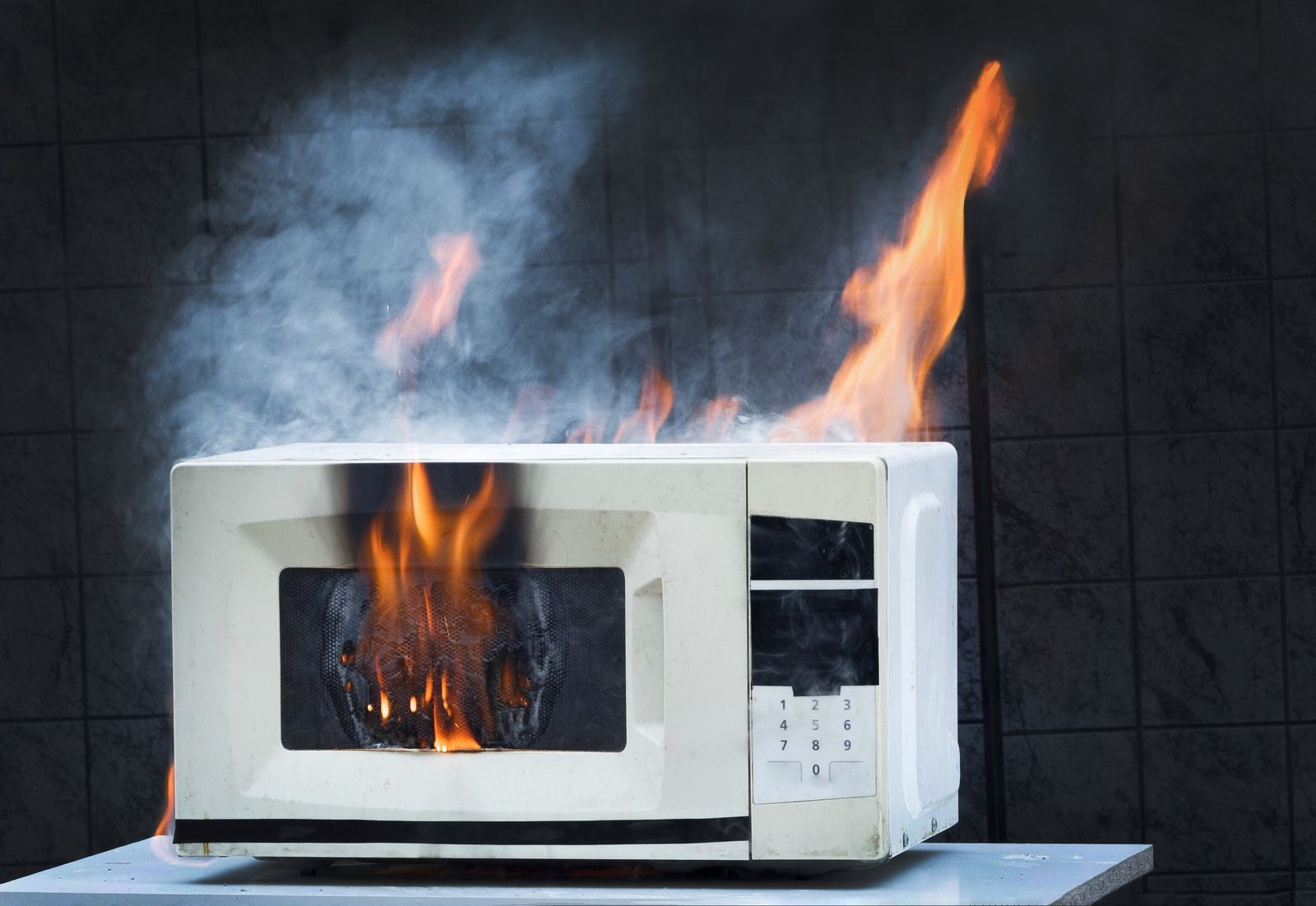 Ein Junge mit einem Fußball vor einem zerbrochenen Fenster und sein besorgter Vater